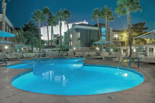 a swimming pool at night with palm trees at Wyndham Desert Rose Resort 2BR Apartment with Resort Access in Las Vegas