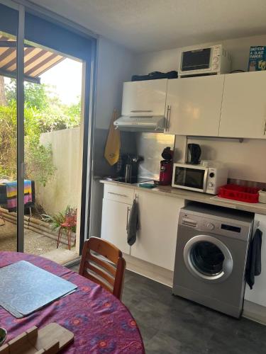 une cuisine avec un lave-linge et un micro-ondes dans l'établissement Studio avec parking proche de la plage, à Argelès-sur-Mer