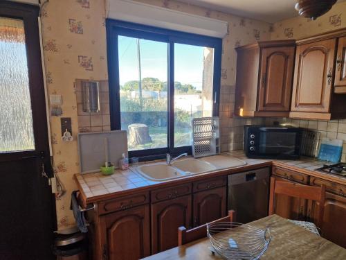 une cuisine avec un évier et une fenêtre dans l'établissement la mer à 200m, au Grau-dʼAgde