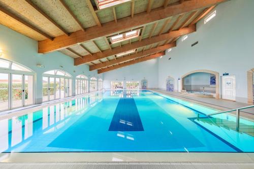 a large indoor swimming pool with blue water at Family Escape, oasis parque in Portimão