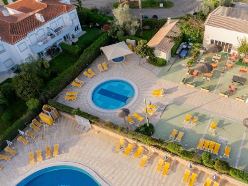 an overhead view of a swimming pool and chairs and a house at Family Escape, oasis parque in Portimão