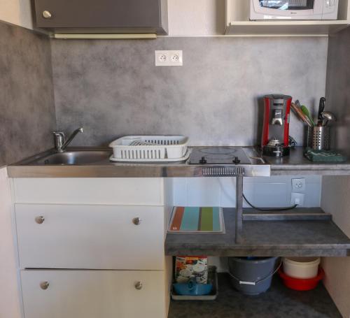 une petite cuisine avec un évier et une cuisinière dans l'établissement Azeos by POM, au Cap d'Agde