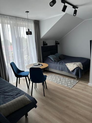 a bedroom with a bed and a table and chairs at Villa Na Fali in Grzybowo