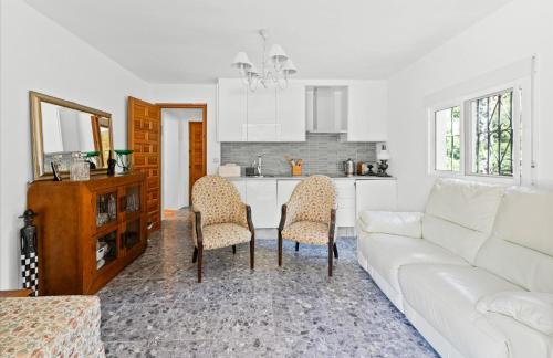 a living room with a couch and a table and chairs at Casa de las Risas B&B in Alhaurín el Grande