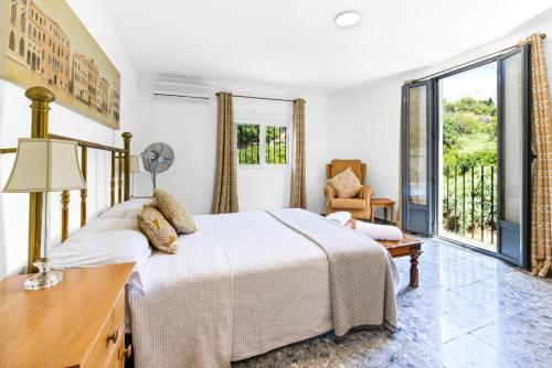 a bedroom with a bed and a desk and a window at Casa de las Risas B&B in Alhaurín el Grande