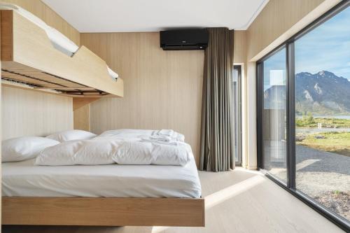 a bedroom with a bed and a large window at NEW - Seafront Luxury Villa near Henningsvær in Kleppstad