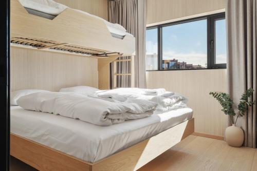 a bedroom with a bed with white sheets and a window at NEW - Seafront Luxury Villa near Henningsvær in Kleppstad