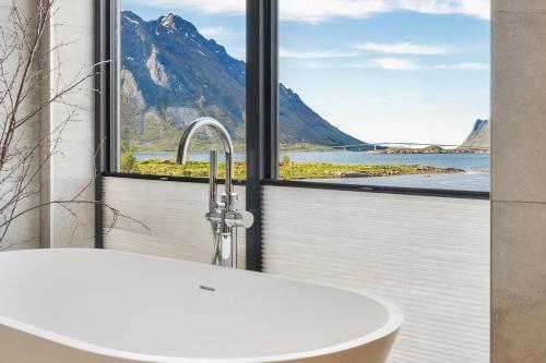 a bathroom with a tub and a view of a mountain at NEW - Seafront Luxury Villa near Henningsvær in Kleppstad