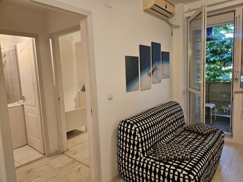 a black and white chair in a room with a window at D&D Apartment in Mamaia Nord