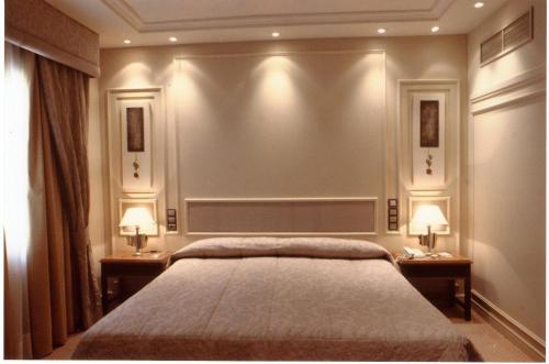a bedroom with a bed and two tables with lamps at Hotel Olid in Valladolid