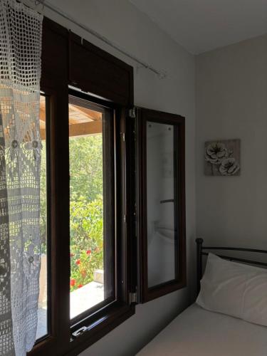 - une chambre avec une fenêtre à côté d'un lit dans l'établissement The Garden House, Sitia, à Siteía
