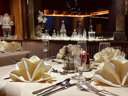 a table in a restaurant with white tablecloths and silverware at Gasthof Oberwirt in Gerlos