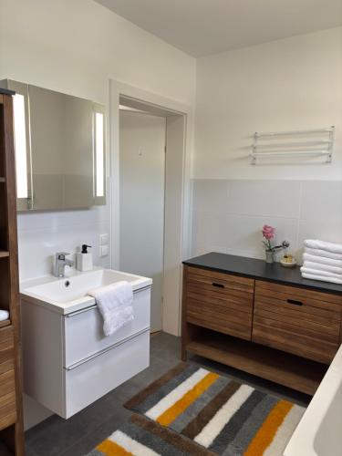 a white bathroom with a sink and a mirror at Unicorn Apartment in Nüziders