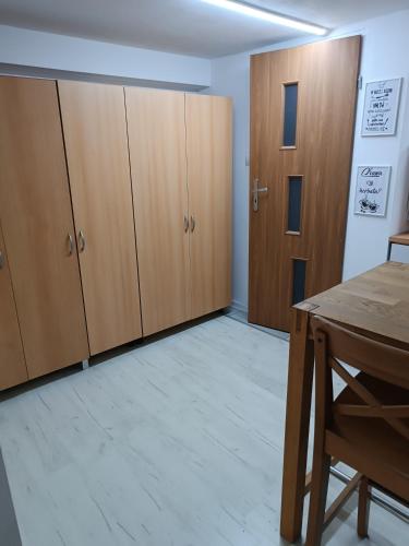 a room with wooden cabinets and a table at Agroturystyka Rudy Kocur Różana 24 Jaroszowice in Jaroszowice