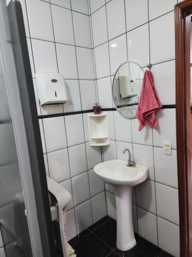ein weißes Badezimmer mit Waschbecken und Spiegel in der Unterkunft Cabana Hostel nas Árvores EcoPark in São Pedro