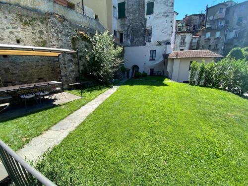a grassy yard with a picnic table and a building at Casa Brown - con piscina privata - in Barga