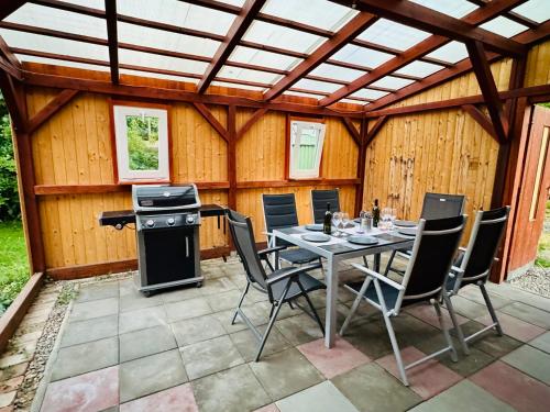a patio with a table and chairs and a stove at Pálava Chalupa in Pavlov