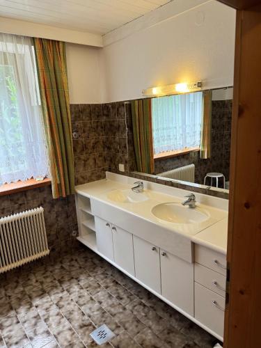 a bathroom with two sinks and a mirror at Schönmoosalm in Krimml