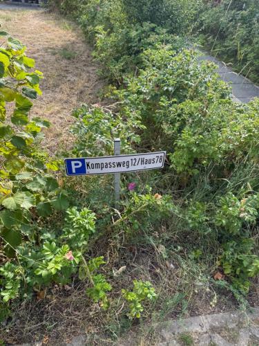 a blue and white street sign in a garden at Seeschwalbe 78 Kompassweg in Rechlin