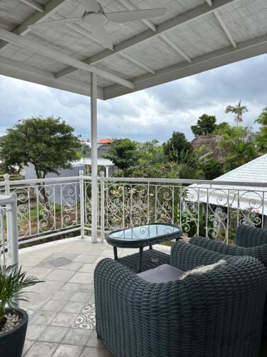 a patio with chairs and a table on a balcony at villa Angin in Munggu