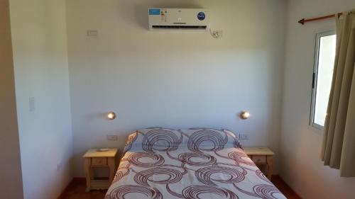 una piccola camera con un letto con una coperta di La Serena Cabañas a Potrero de los Funes