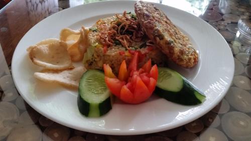 a plate of food with sausage and vegetables on a table at Ubud Paradise Villa in Ubud