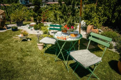 a table with two chairs and a table with flowers on it at Apartmany pod Pustevnami in Prostřední Bečva