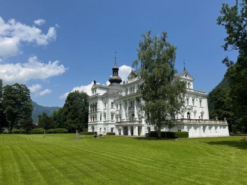 a large white building with a tree in a field at "Drei Buben" - Moderne Ferienwohnung in St Martin bei Lofer, NEU ab Sommer 2025 in Sankt Martin bei Lofer