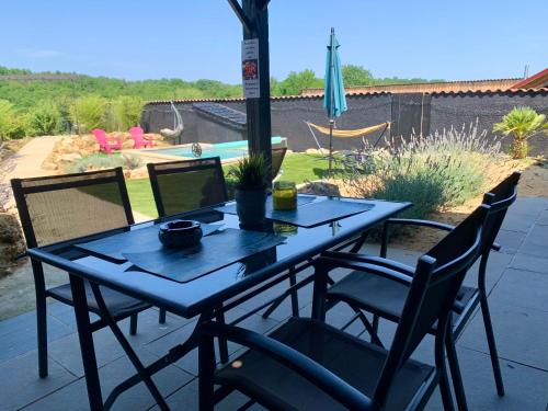 une table et des chaises bleues sur une terrasse dans l'établissement Le 007 Refuge -Rurale gîte élégant piscine privée, à Queyssac