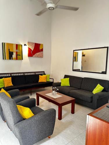 a living room with couches and a coffee table at Frangipani House in Oruwala