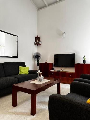 a living room with a couch and a coffee table at Frangipani House in Oruwala