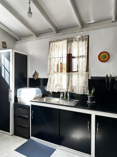 a kitchen with a sink and a window at Frangipani House in Oruwala