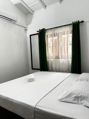 a large bed in a room with a window at Frangipani House in Oruwala