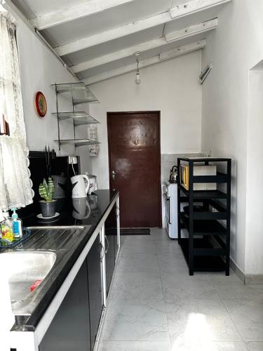 a kitchen with a sink and a brown door at Frangipani House in Oruwala