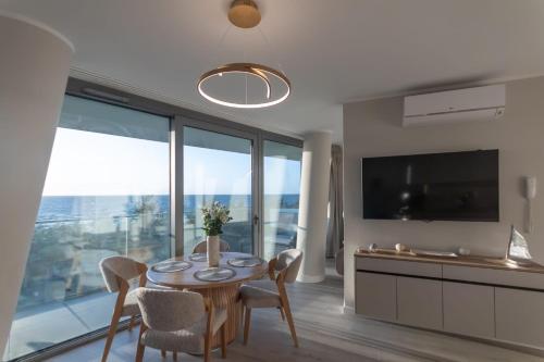 a dining room with a table and chairs and a television at Waveview Premium Apartment Międzyzdroje in Międzyzdroje