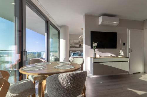 a living room with a table and chairs and a television at Waveview Premium Apartment Międzyzdroje in Międzyzdroje