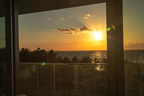 a sunset view from a window of a house at Waveview Premium Apartment Międzyzdroje in Międzyzdroje