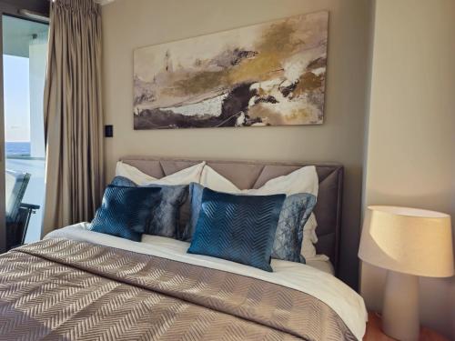 a bedroom with a bed with blue and white pillows at Waveview Premium Apartment Międzyzdroje in Międzyzdroje