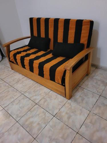 a wooden couch sitting on top of a tile floor at Casa da Alegria in São Tiago