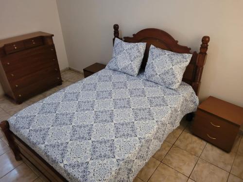 a bedroom with a bed with a blue quilt at Casa da Alegria in São Tiago
