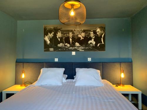 une chambre avec un lit avec un tableau sur le mur dans l'établissement Le 007 Refuge -Rurale gîte élégant piscine privée, à Queyssac