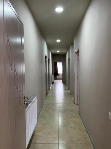 a hallway with a long corridor with doors and a tile floor at ბორითი-Boriti in Kharagauli