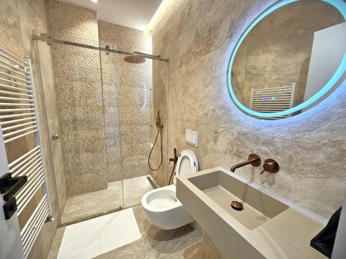 a bathroom with a sink and a toilet and a mirror at La Terrazza Azzurra in Vlorë
