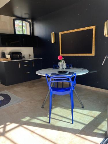 a blue table and a blue chair in a kitchen at Les Ecuries de Rigny, Suite haut de gamme avec jardin, jacuzzi et piscine in Nancy