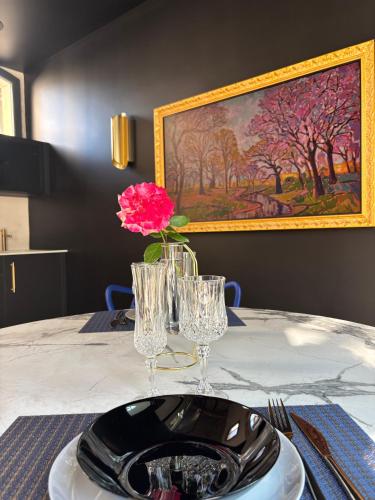 a table with a plate and a pink flower on it at Les Ecuries de Rigny, Suite haut de gamme avec jardin, jacuzzi et piscine in Nancy