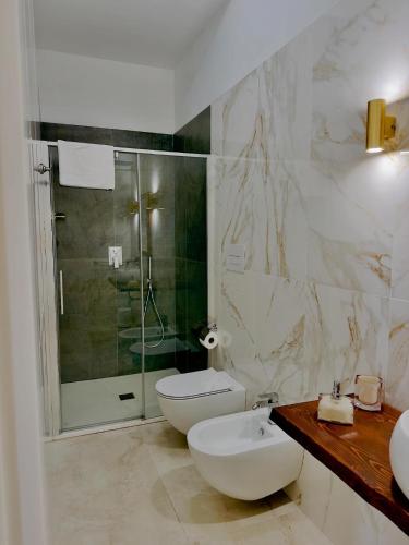 a white bathroom with a toilet and a shower at Villa Romilda in Ascea