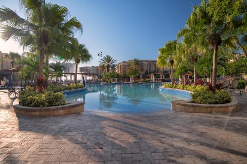 a swimming pool with palm trees in a resort at Wyndham Bonnet Creek 2BR Apartment with Resort Access in Orlando