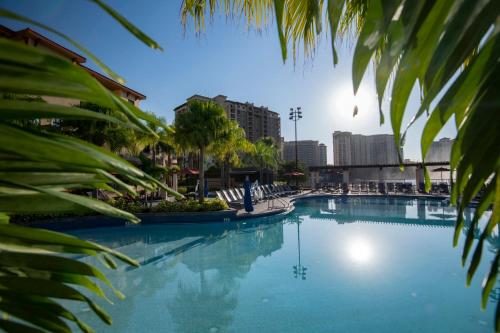 a large swimming pool with palm trees and buildings at Wyndham Bonnet Creek 2BR Apartment with Resort Access in Orlando