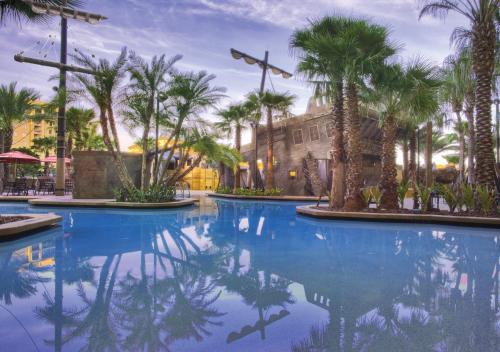 a pool with palm trees and a building at Wyndham Bonnet Creek 2BR Apartment with Resort Access in Orlando