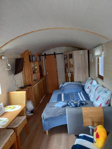 a room with a bed and a couch in a boat at Cottage-Irina in Brandenburg an der Havel